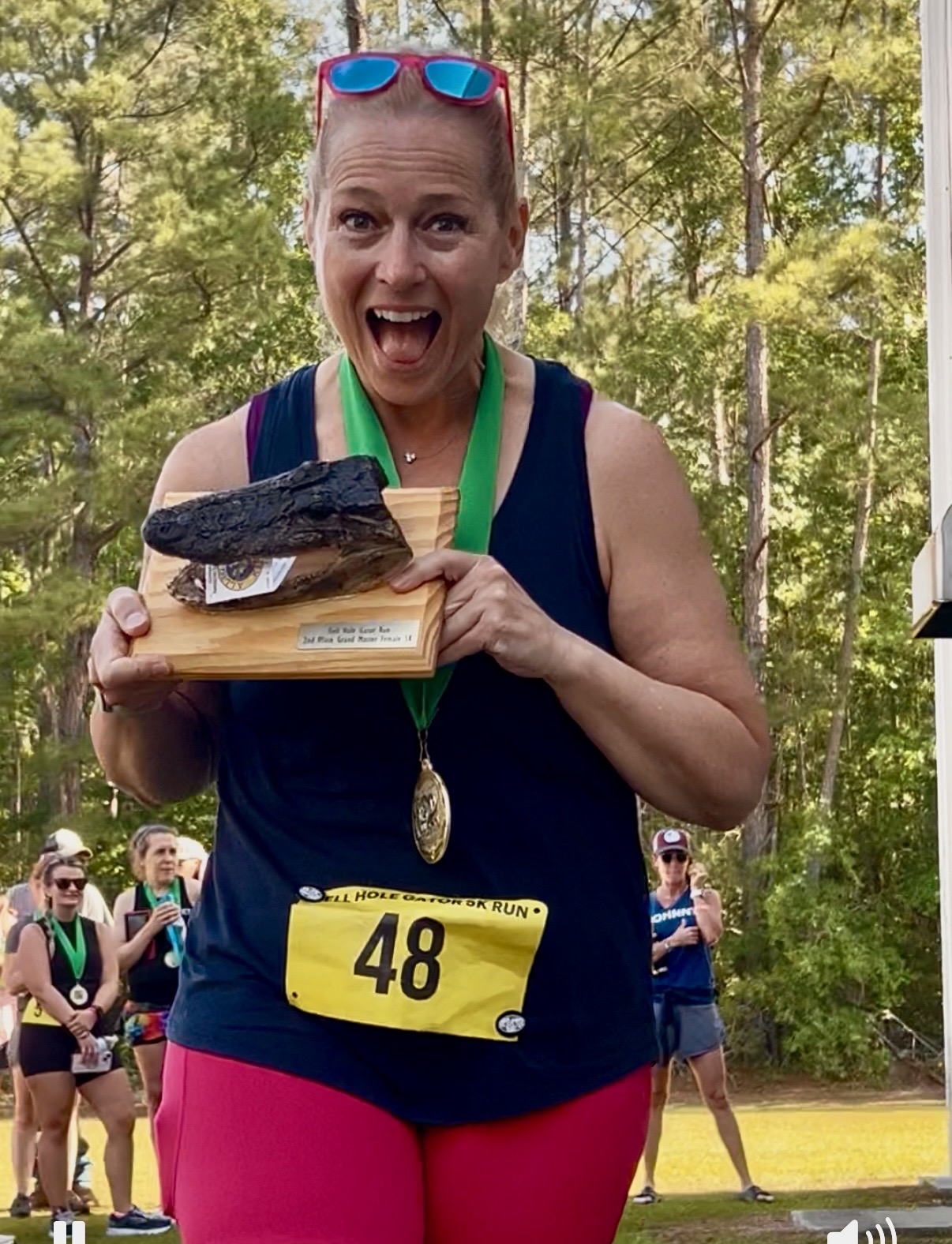 Cyndee Cave holding a gator trophy after winning her age group at the Hell Hole Gator 5K race.